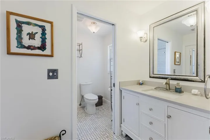 Bathroom with baseboards, vanity, and toilet