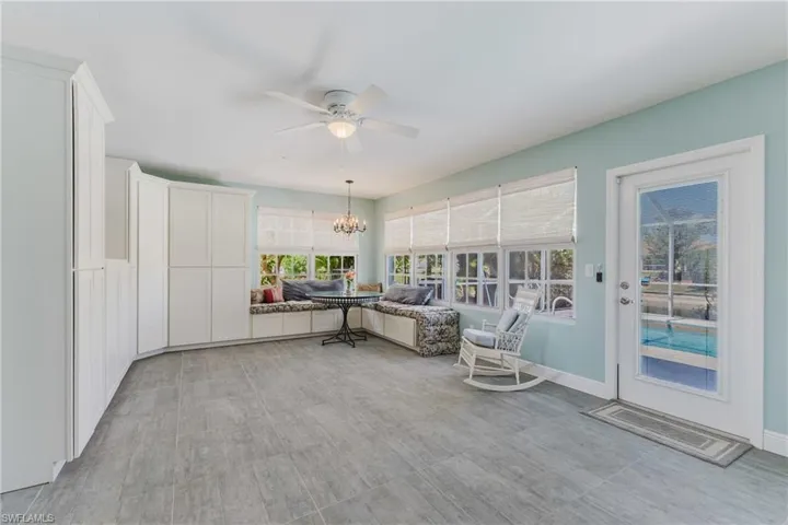 Sunroom / solarium featuring a chandelier and baseboards