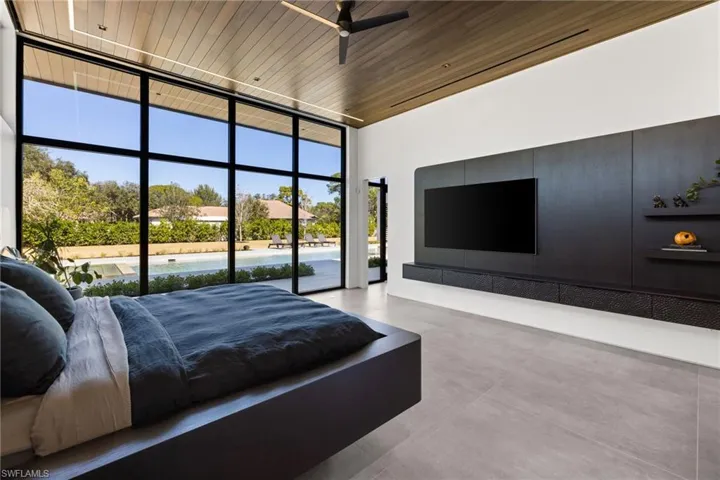 Bedroom featuring access to outside, expansive windows, wooden ceiling, and concrete flooring