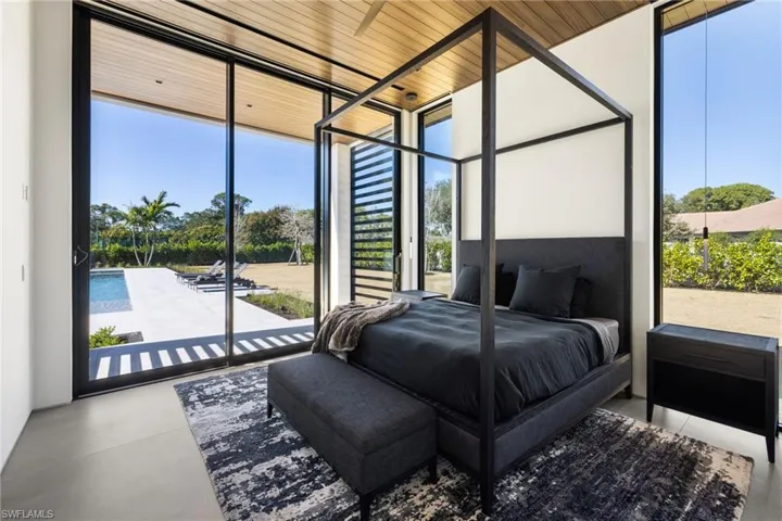 Bedroom featuring concrete floors, access to outside, floor to ceiling windows, and wood ceiling