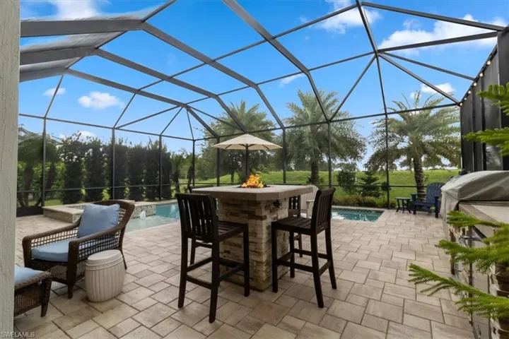 View of patio featuring glass enclosure and pool water feature