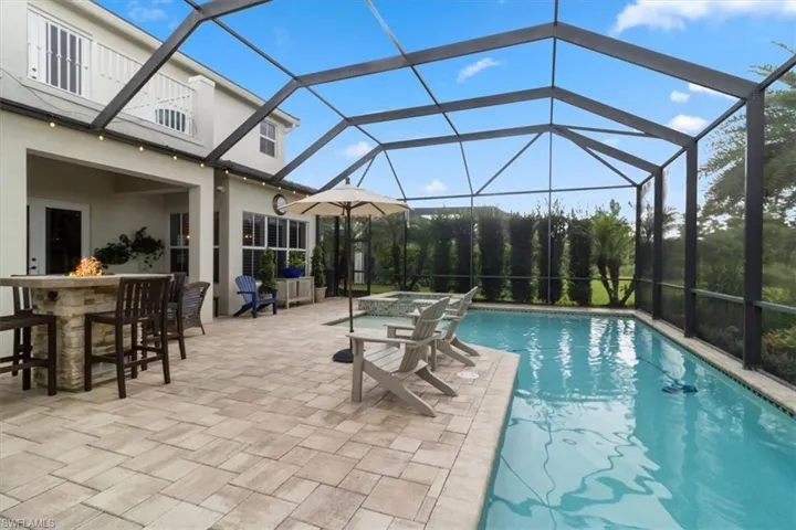 View of pool with a lanai, exterior bar, and a patio