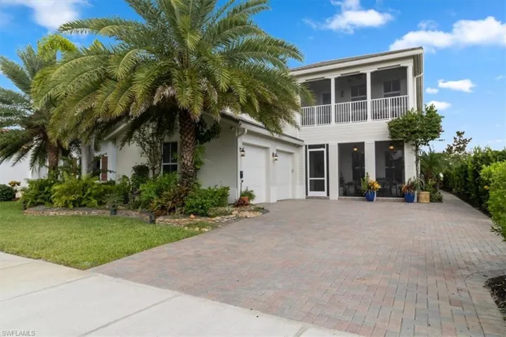 View of front of property featuring a garage and a front lawn