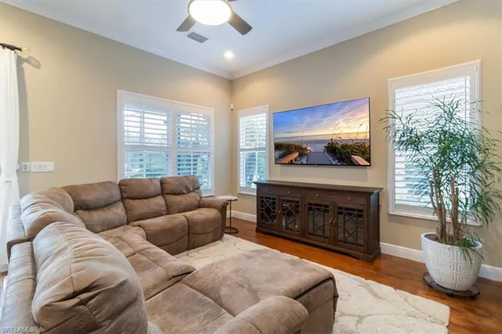 Living room featuring ceiling fan, crown molding, and hardwood / wood-style floors