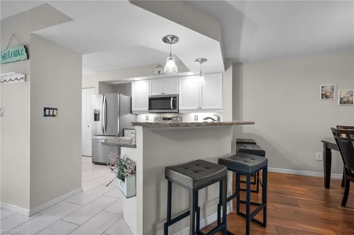 Kitchen featuring white shaker cabinetry, stainless steel appliances, and stone countertops
