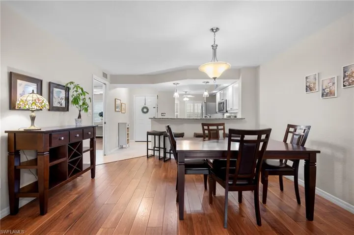 Dining area featuring wood-finish flooring and a central pendant light fixture