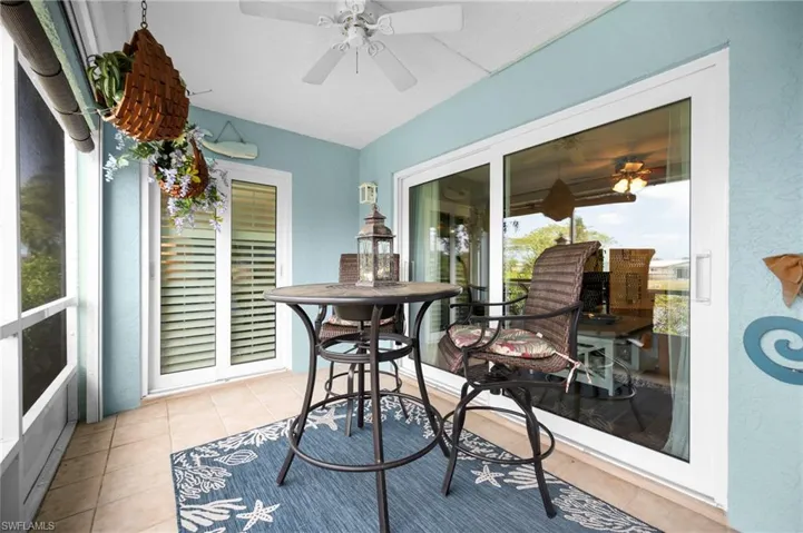 Screened porch featuring light blue walls and a white ceiling fan