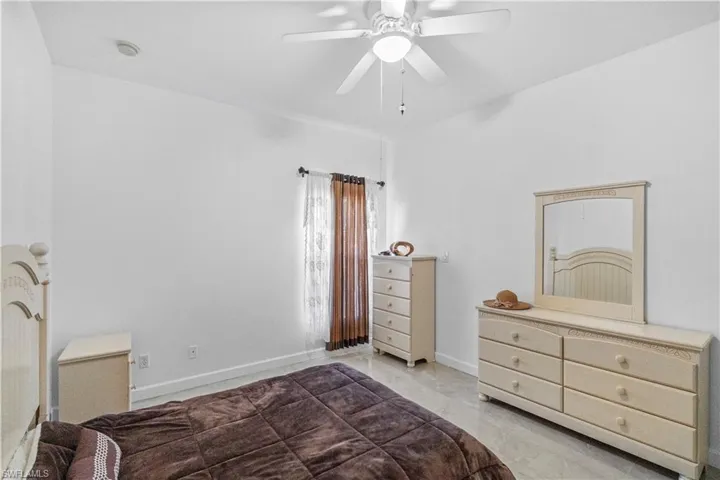 Bedroom with ceiling fan and baseboards