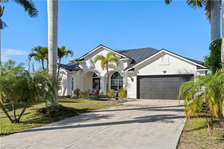View of front of property with stucco siding, concrete driveway, a garage, and a front yard