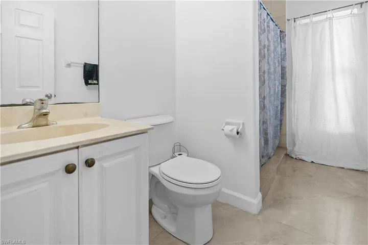 Bathroom featuring a shower with shower curtain and vanity