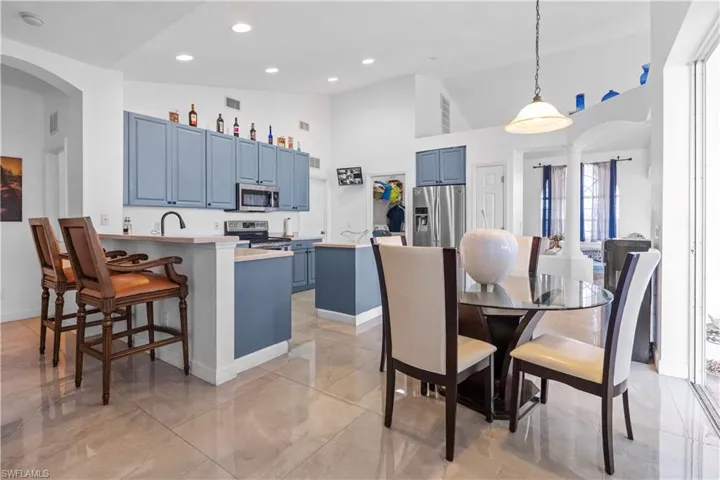 Dining area featuring arched walkways and lofted ceiling