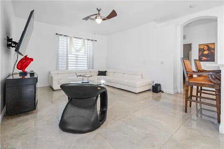 Living room featuring ceiling fan and baseboards