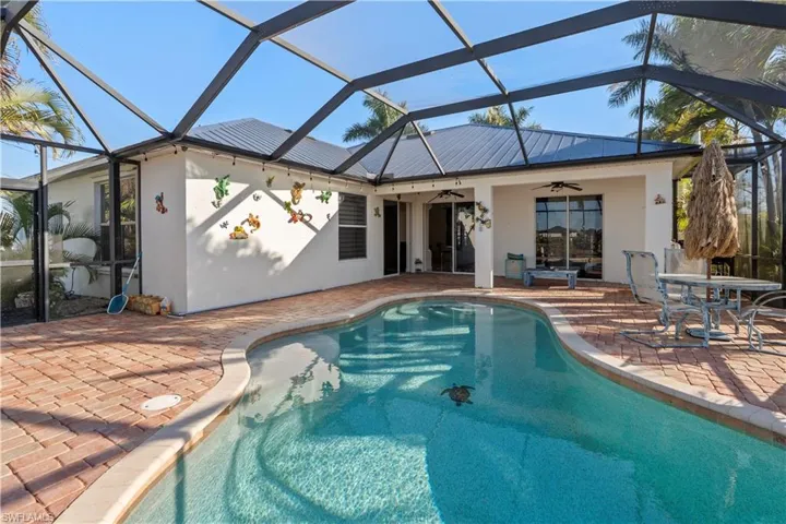 Outdoor pool with a sunroom, glass enclosure, a patio, and outdoor dining space