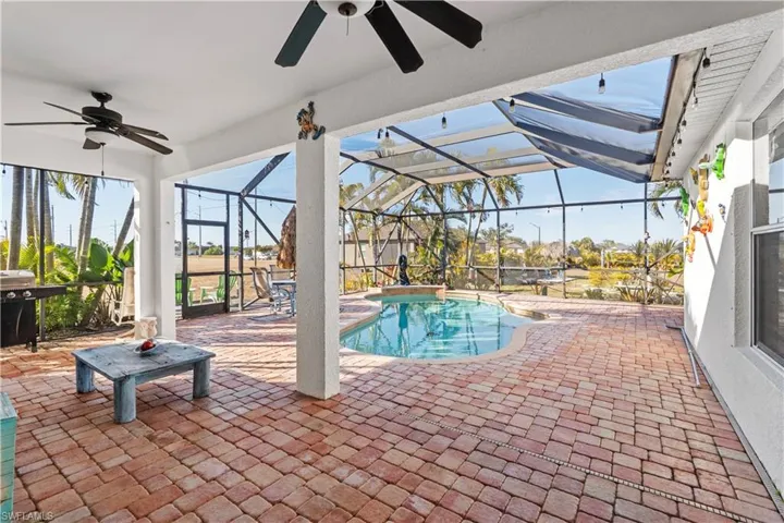 Swimming pool with a patio area, a sunroom, a lanai, and area for grilling