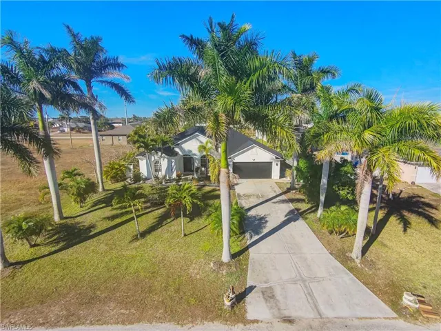 View of front of house featuring concrete driveway and a front lawn