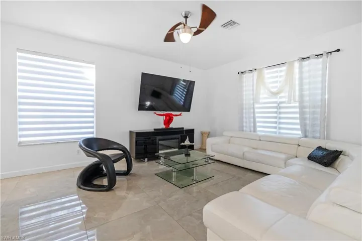 Living room with ceiling fan and baseboards