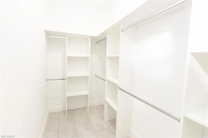 Walk in closet with light tile patterned flooring