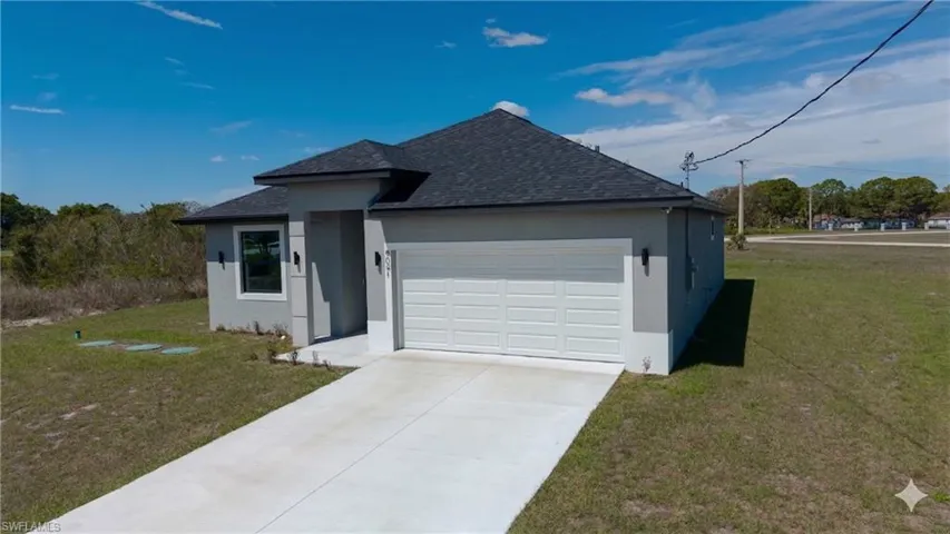 View of front of home featuring a front lawn, roof with shingles, stucco siding, a garage, and concrete driveway