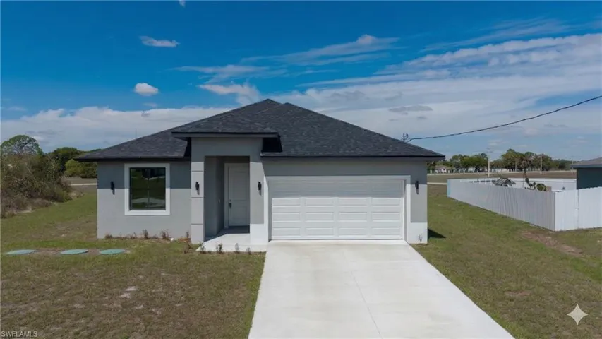 Ranch-style home featuring roof with shingles, stucco siding, an attached garage, and driveway