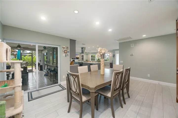 Recessed lighting, light wood-finish flooring, sliding glass doors, built-in cabinetry, and neutral wall tones