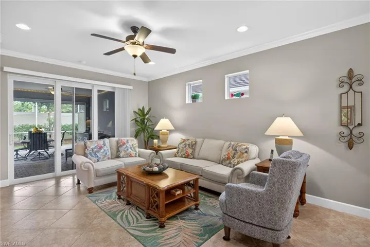 Living area featuring neutral wall tones, crown molding, and recessed lighting