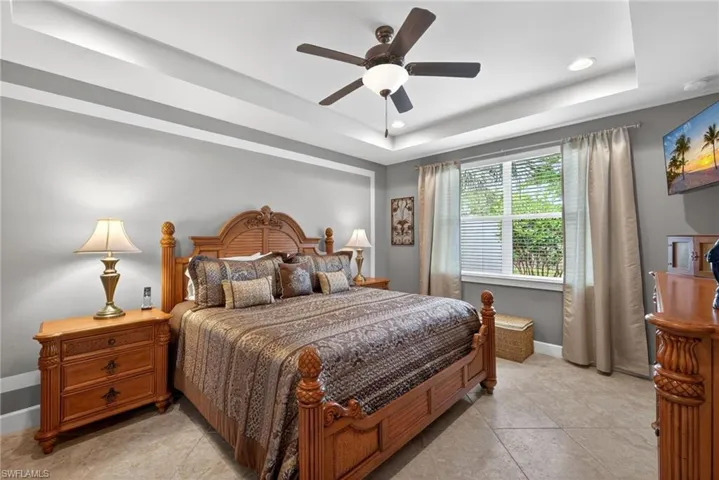 Recessed lighting illuminates the tray ceiling, complemented by a ceiling fan with integrated light fixture