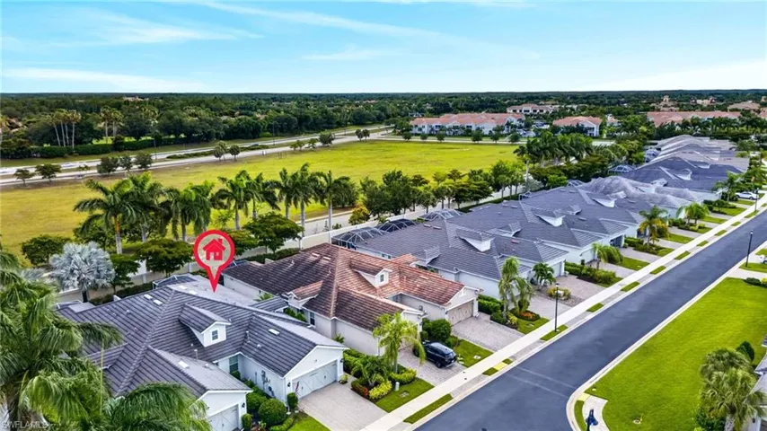 Aerial perspective showcasing a residential community with manicured landscaping and mature palm trees