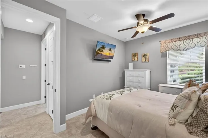 Carpeted room featuring a ceiling fan with integrated lighting, a window with blinds, and white trim