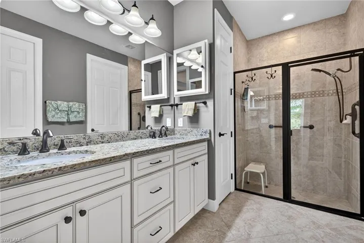 Dual sink vanity with stone-finish countertop and white cabinetry
