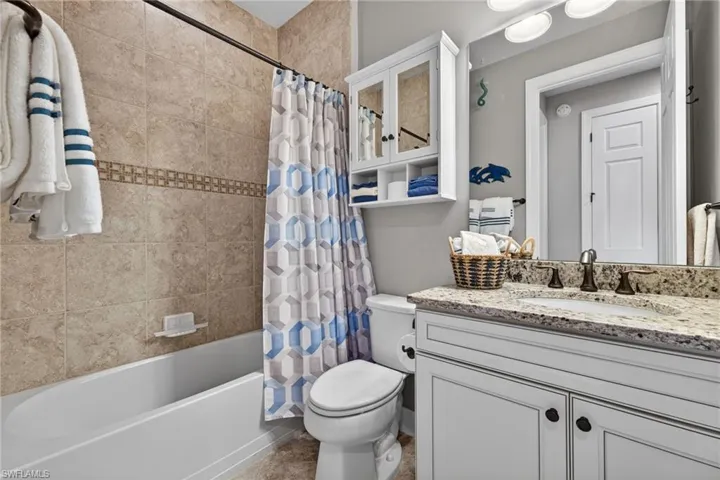 Bathroom featuring a shower/tub combination with tile surround and decorative accent band