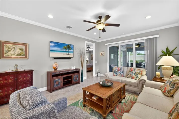 Spacious living area featuring light gray walls, crown molding, recessed lighting, and a ceiling fan