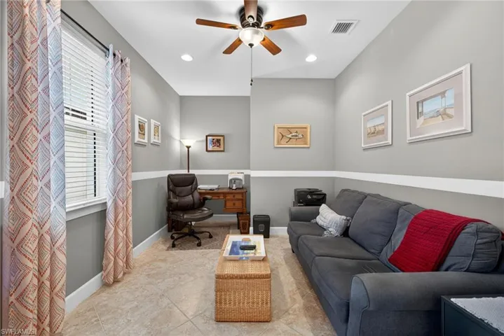 Versatile room featuring tile flooring, a window with blinds, a ceiling fan with light fixture, recessed lighting, and a two-tone wall treatment with a chair rail
