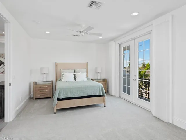 Carpeted bedroom with access to outside, ceiling fan, and french doors