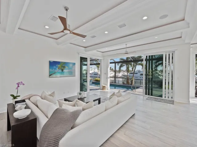 Living room featuring ceiling fan, light hardwood / wood-style floors, and beamed ceiling