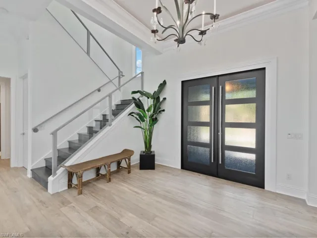 Entrance foyer featuring a healthy amount of sunlight, french doors, and crown molding