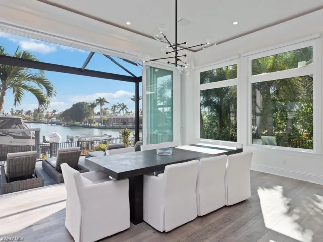 Dining space with a water view, wood-type flooring, and a chandelier