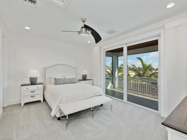 Carpeted bedroom with ceiling fan and access to exterior