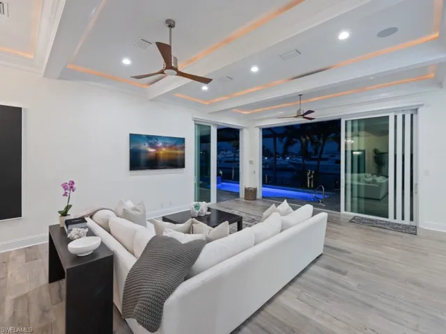 Living room featuring ceiling fan, beamed ceiling, and light hardwood / wood-style flooring