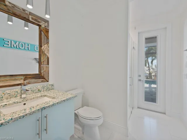 Bathroom with toilet, tile patterned flooring, an enclosed shower, ornamental molding, and vanity