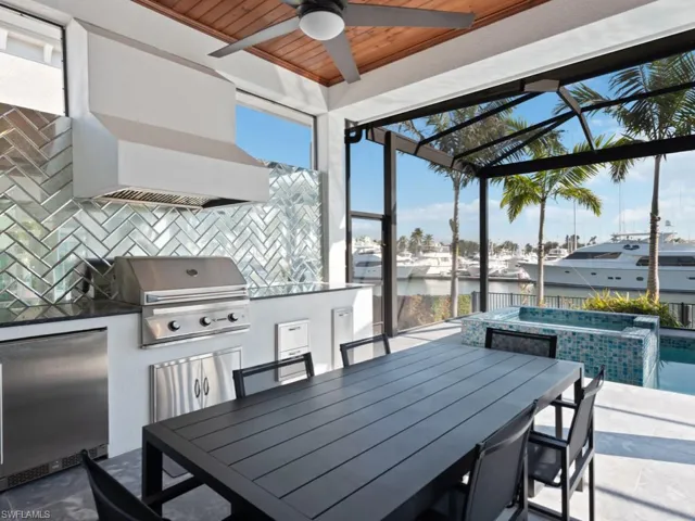 View of patio / terrace featuring a water view, exterior kitchen, and a grill