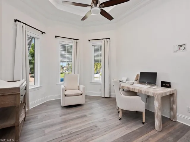 Office area featuring ceiling fan, wood-type flooring, and ornamental molding