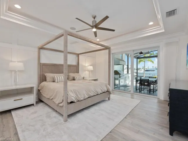 Bedroom featuring ceiling fan, access to exterior, light hardwood / wood-style floors, and ornamental molding