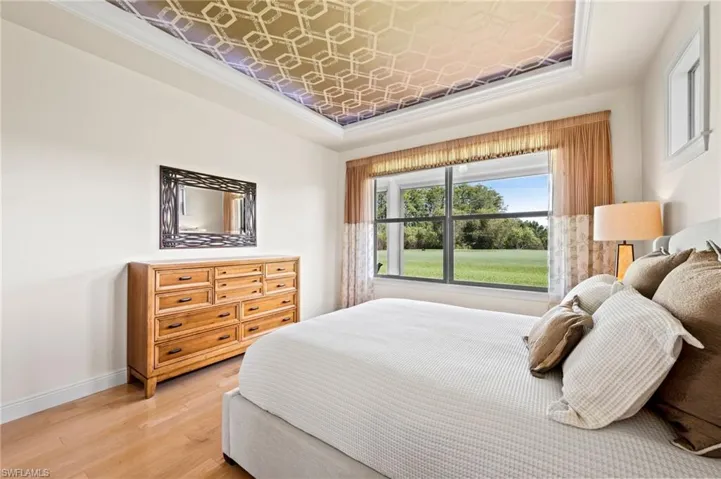 Primary Bedroom with views of lawn, golf course and wooded area beyond.