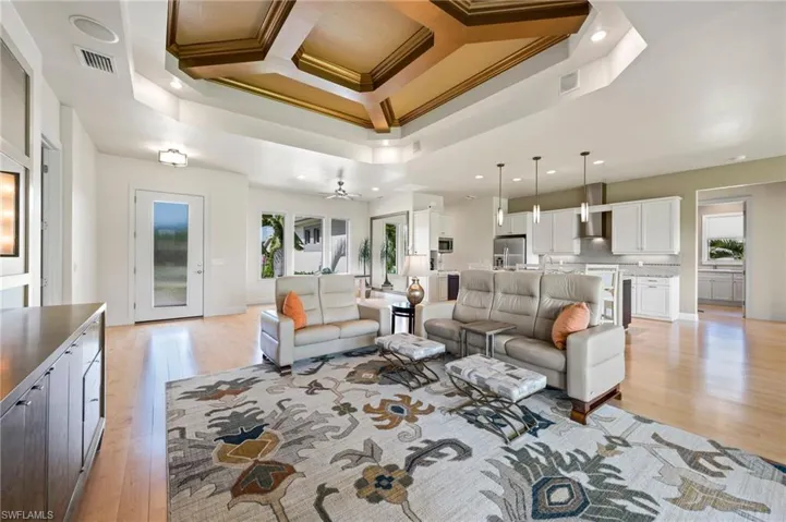 Another view of large great room with coffered tray ceilings