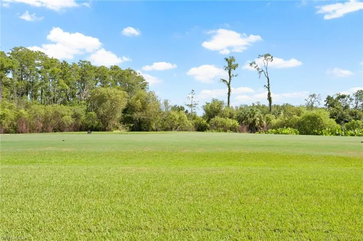 Lawn view to course and wooded area beyond.