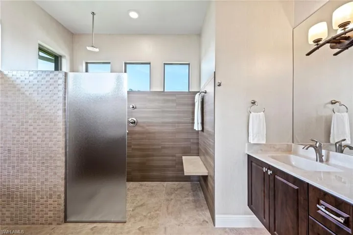 Primary bath with separate vanities and walk in zero entry shower with lots of light