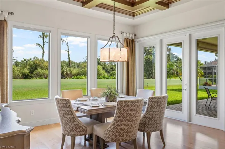 Informal dining area with views to lawn, golf course and wooded area beyond