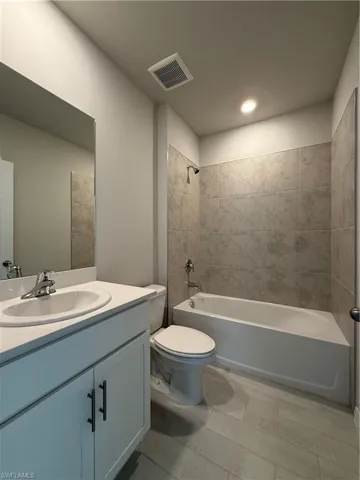 Bathroom with vanity, toilet, and bathing tub / shower combination