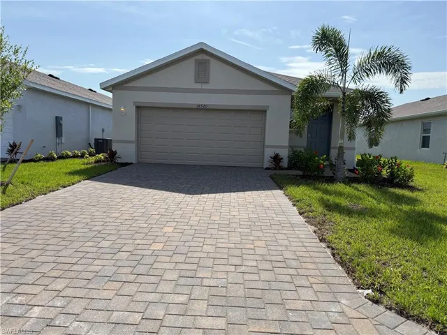 Single story home featuring decorative driveway, stucco siding, central air condition unit, and a front yard