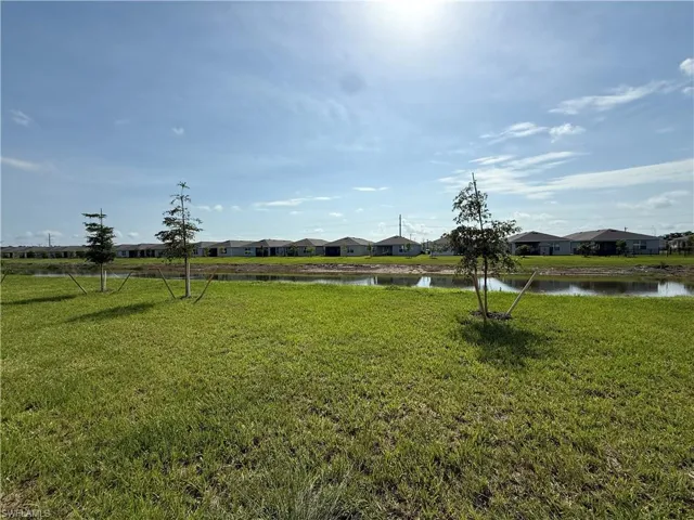 View of green lawn featuring a water view and a residential view
